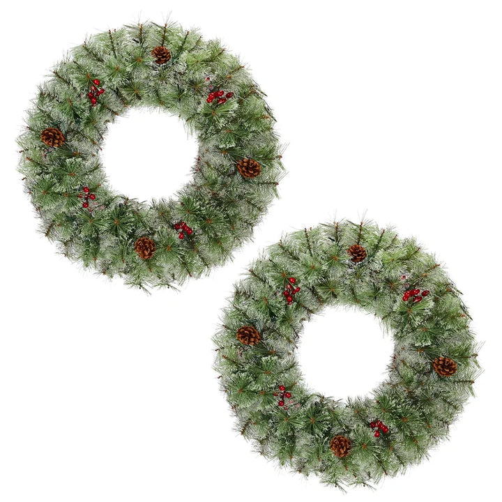 Two lit Christmas wreaths on a front door
