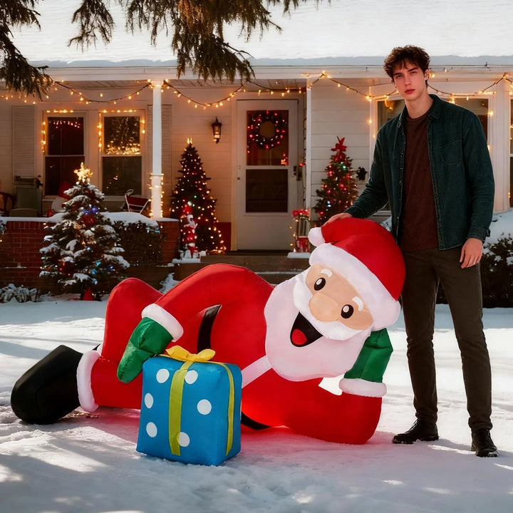 Inflatable Santa lying on lawn with gift
