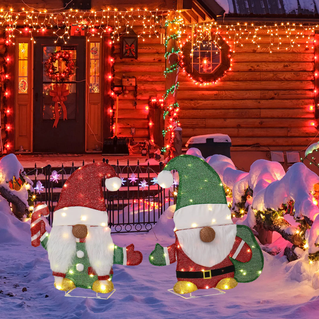 Two lighted Christmas gnomes in a yard