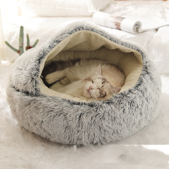 Cat curled up in a round plush bed with hood