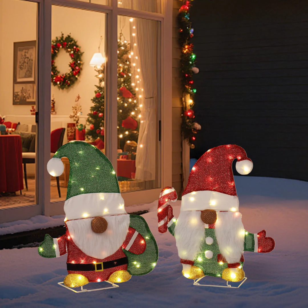 Two lighted Christmas gnomes in a yard