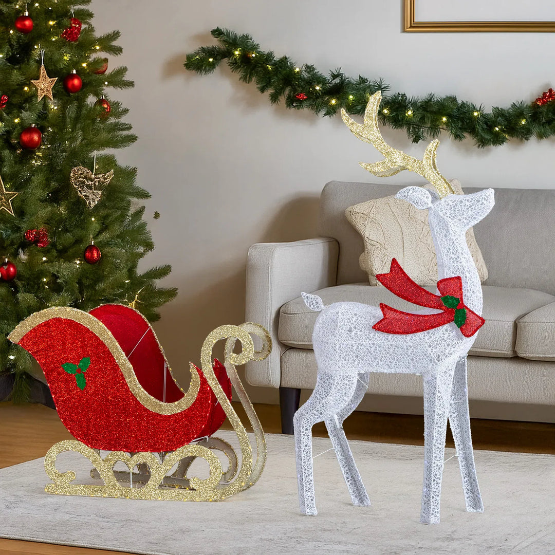 Lighted reindeer and sleigh at night