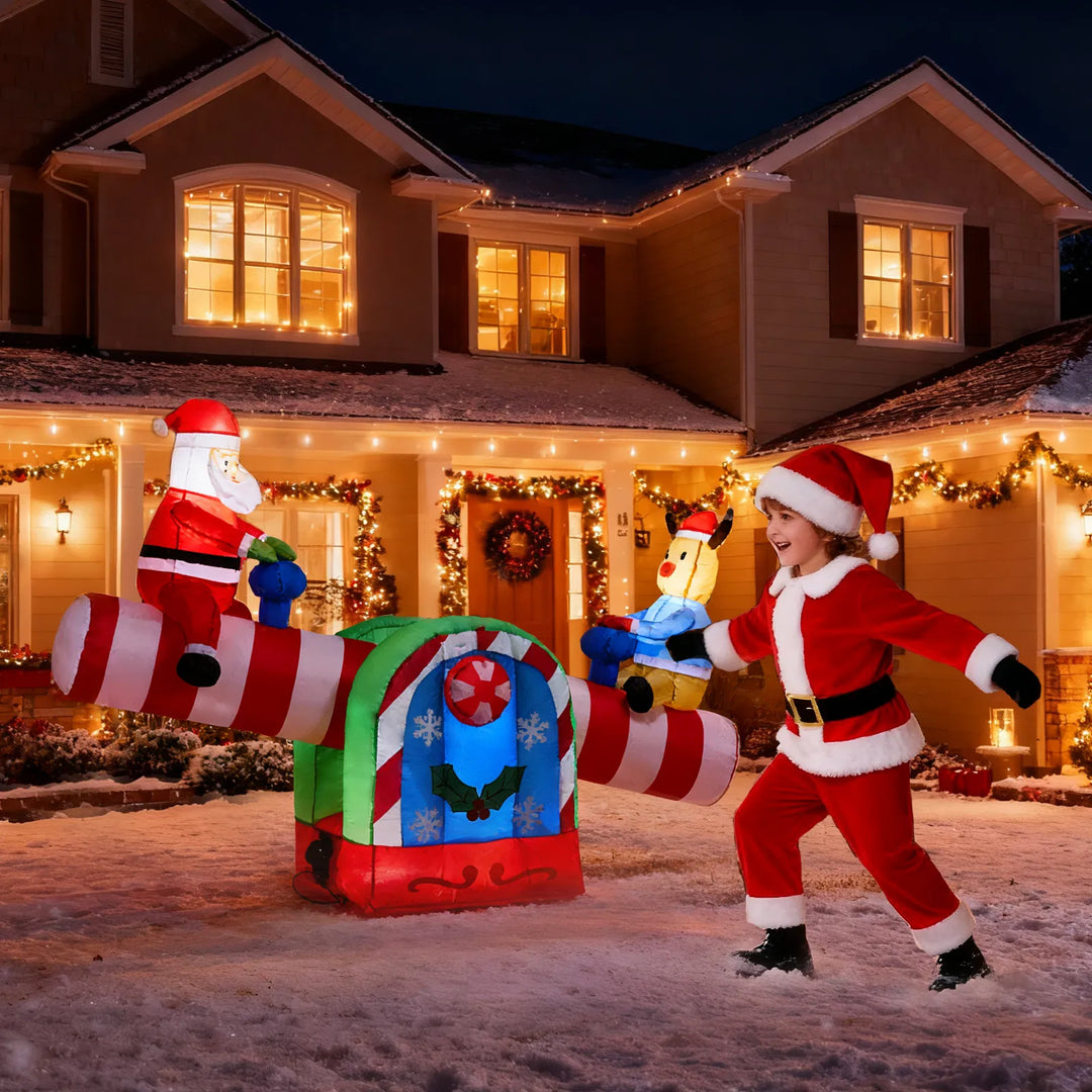 Inflatable Santa and reindeer seesaw lit at night