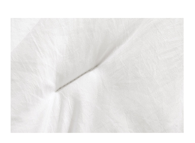 White box stitched comforter on a bed
