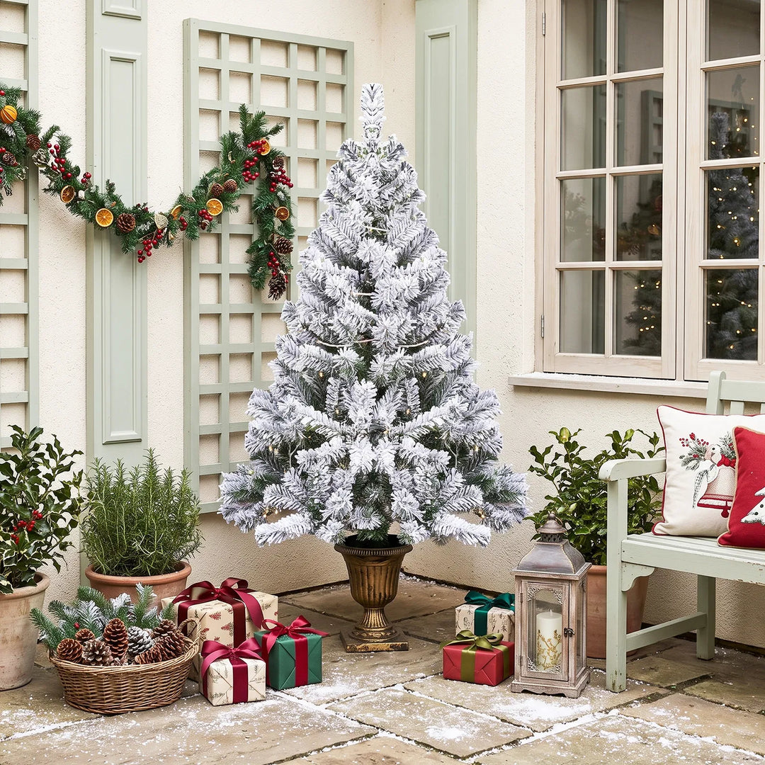 Small flocked Christmas tree in pot lit
