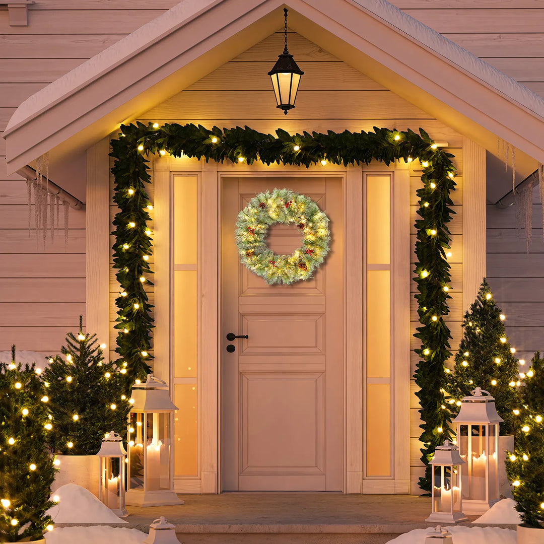 Two lit Christmas wreaths on a front door