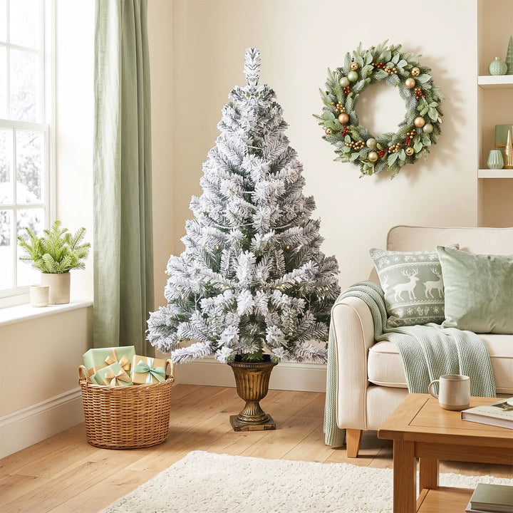 Small flocked Christmas tree in pot lit