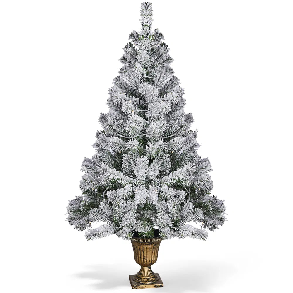 Small flocked Christmas tree in pot lit