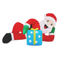 Inflatable Santa lying on lawn with gift